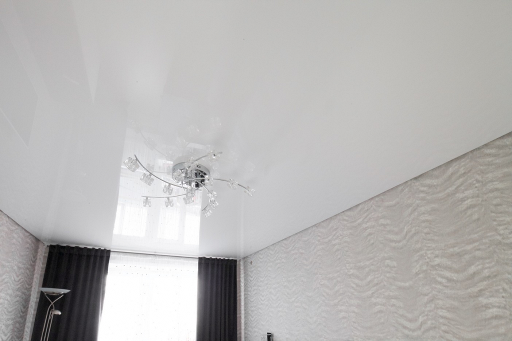 Белый глянцевый натяжной потолок в спальне